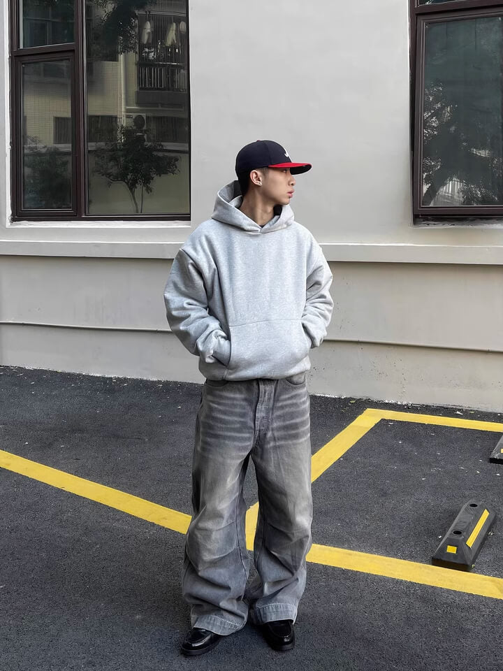 Rückansicht eines Models, das den Hellgrauen Heavyweight The Gradual Hoodie trägt.