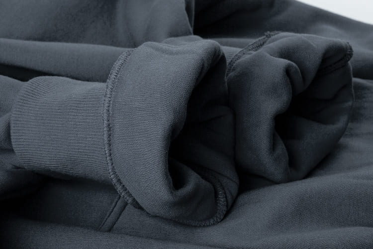 Nahaufnahme der elastischen Rippbündchen am Ärmel des dunkelgrauen The Gradual Hoodies.
